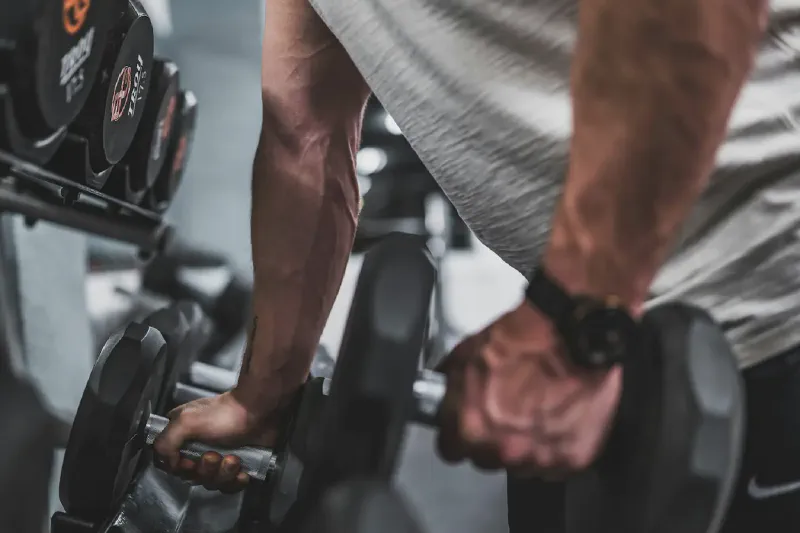 Mancuernas ajustables y fijas colocadas para un gimnasio doméstico compacto
