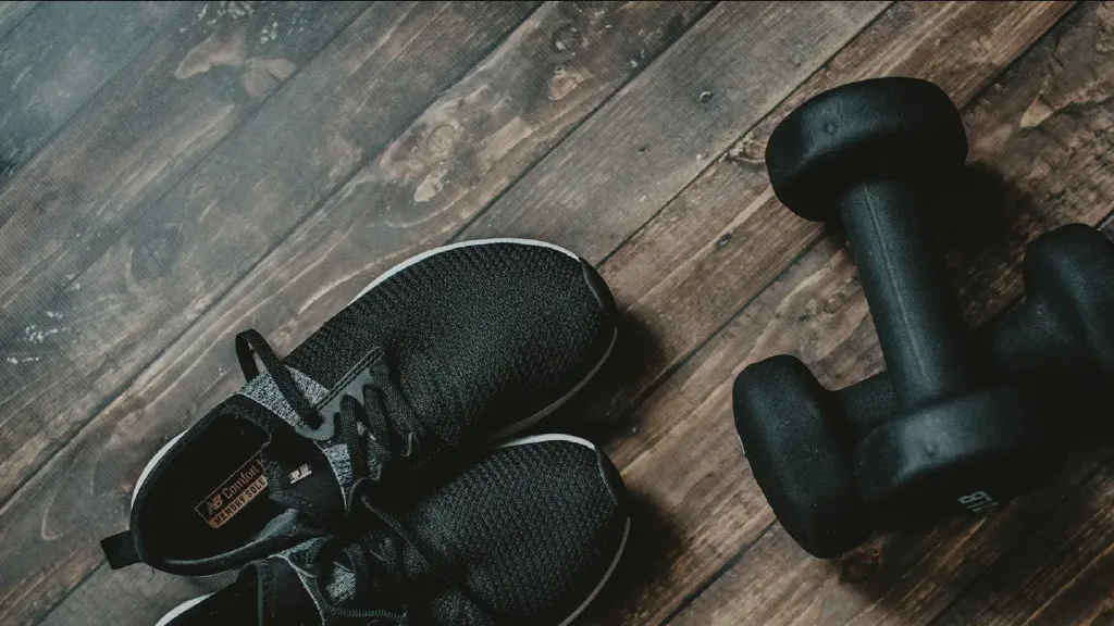 Compact home strength-training area with dumbbells stored neatly beside an exercise mat