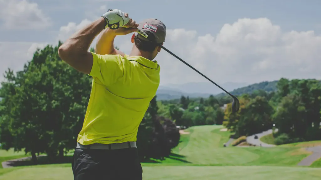 A compact stand golf bag holding a reduced beginner golf club set beside a small hatchback