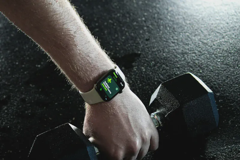 Kompakte Fitness-Accessoires für das Training zu Hause, darunter Widerstandsbänder, ein Suspension Trainer, ein Ab-Roller und Liegestützgriffe, angeordnet in einem kleinen Raum