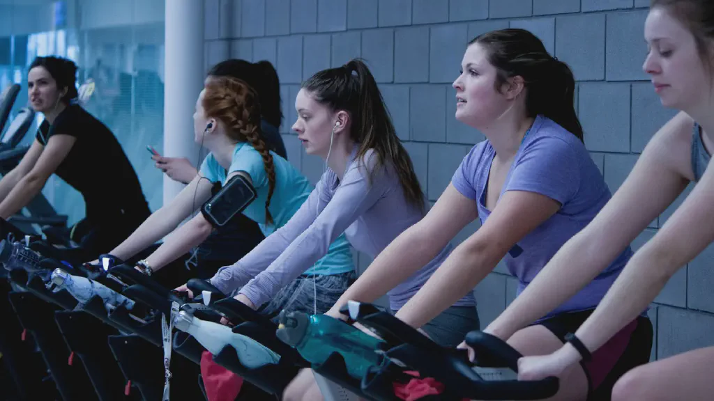 A compact exercise bike positioned on a mat in a small apartment living area