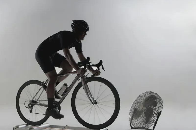 A compact upright exercise bike positioned in a small home workout area beside a wall