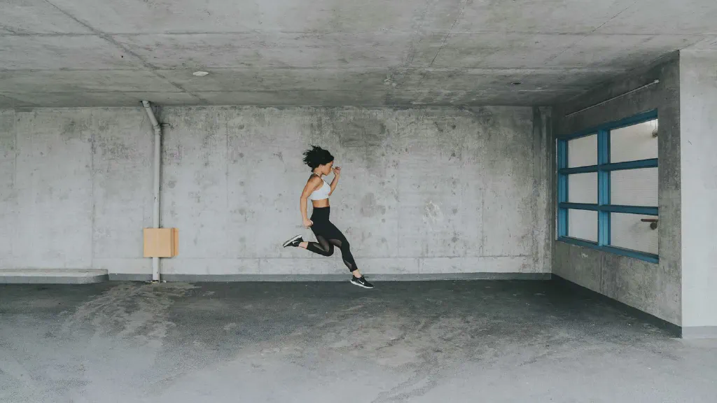 A compact treadmill stored upright beside a wall in a small apartment living area