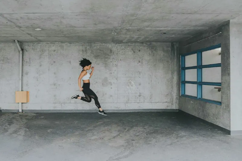 A compact treadmill stored upright beside a wall in a small apartment living area