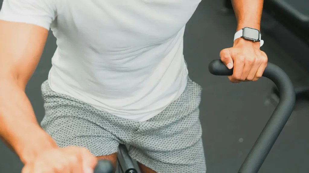 A compact exercise bike positioned in a bright, tidy small home workout area