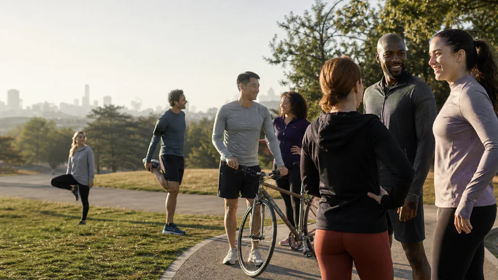 A diverse group of adults meeting for an informal morning activity in a city park